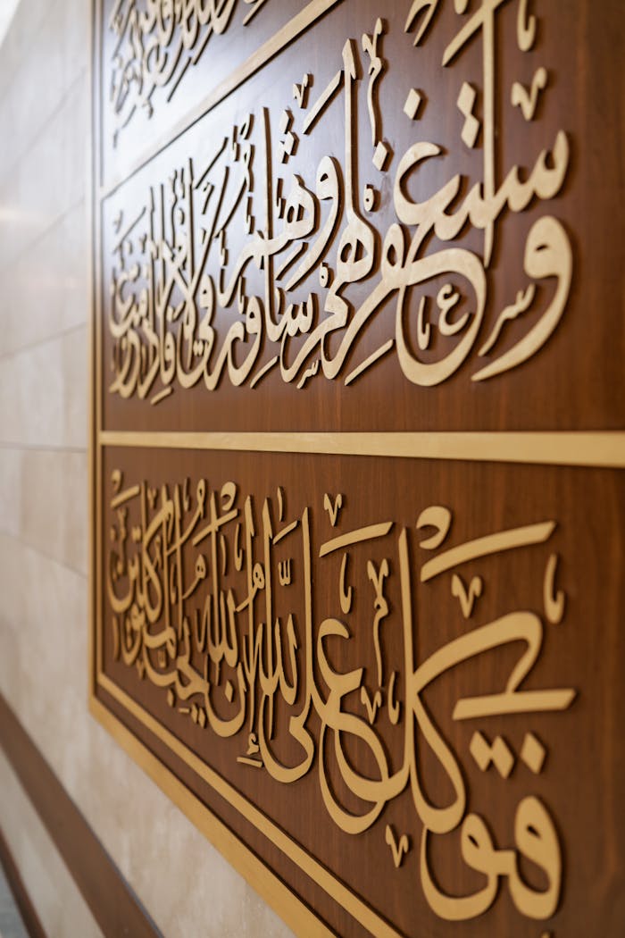 Close-up of elegant Arabic calligraphy on a mosque wall, showcasing Muslim culture.